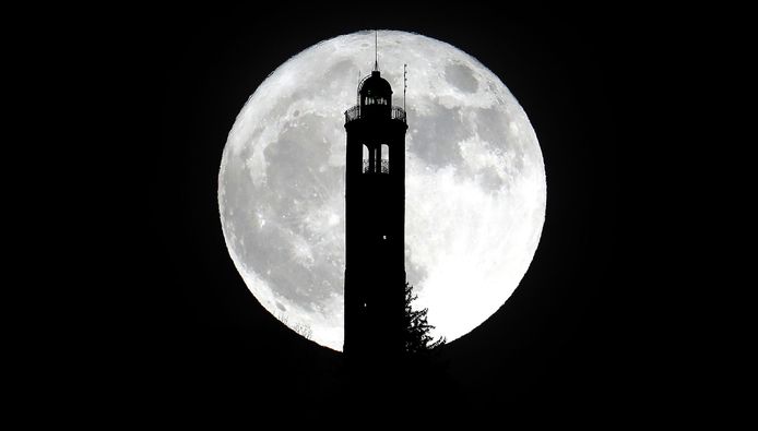 De supermaan boven de toren San Maurizio in Brunate, dicht bij Como, Italië.