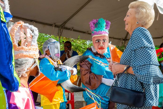 Prinses Beatrix vermaakt zich tijdens haar bezoek aan Bonaire met de maskers van de Maskerade van het bewonersinitiatief Hòfi Kultural.