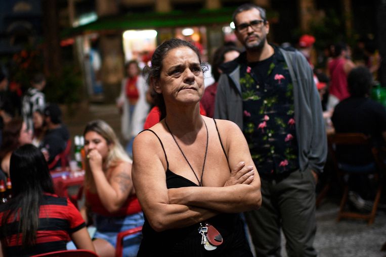 Een aanhanger van Lula bekijkt de peilingen op een groot scherm in Rio de Janeiro. Beeld AFP