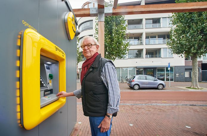 Harry van Ewijk bij de nog vrijwel nieuwe geldkiosk tegenover zijn woning aan de Heschepad. Geldmaat wil de pinmachines terug naar gevel van de Jurgenshof verhuizen.