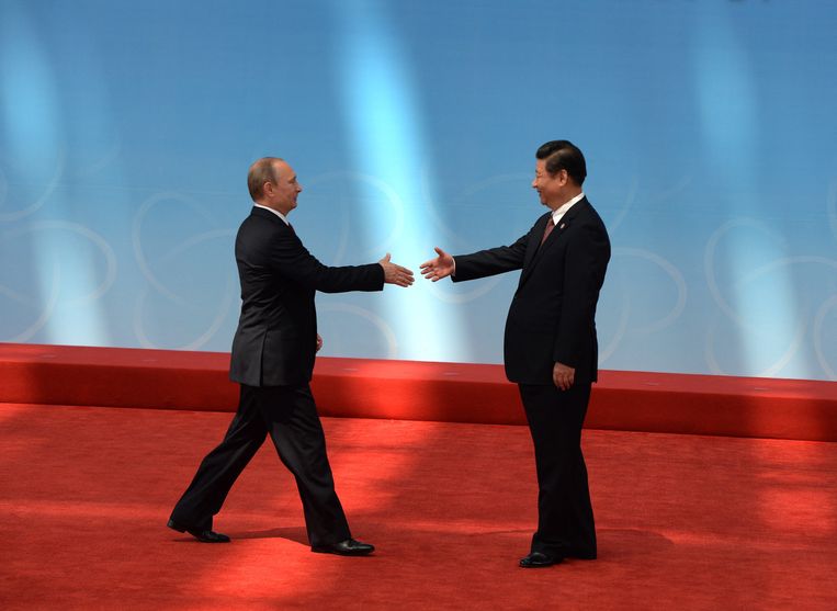 Poetin begroet Xi Jinping tijdens een ceremonie in Shanghai. Beeld AFP