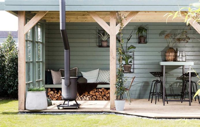 De buitenkamer, een ingerichte living onder een veranda. Compleet met planten en kussens. Het buitenterras wordt huiselijker gemaakt. Styling Leonie Mooren.