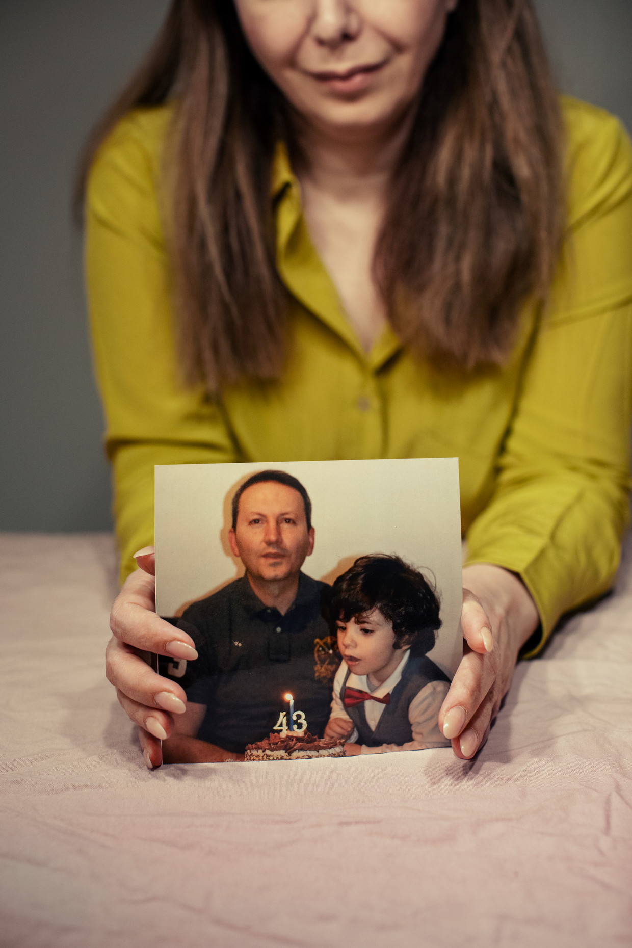 Vida Mehrannia met een foto van haar man en zoon. ‘Amitis (6) weet niet dat zijn vader in de gevangenis zit en ter dood veroordeeld is. Ik kan hem dat nieuws nu nog niet vertellen.’ Beeld Rosie Alm