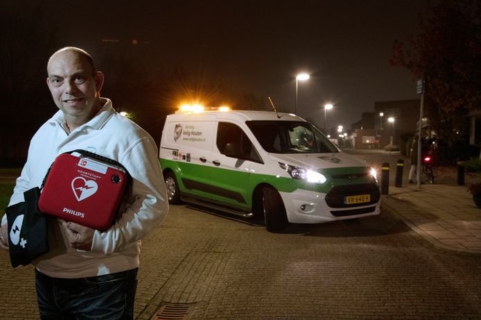 Jeroen Balk van Veilig Houten, met in zijn handen een draagbare AED.
