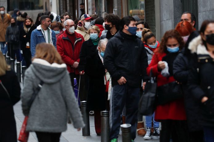 Mensen staan met mondmaskers op in de rij om lottoticketjes te kopen in de Spaanse hoofdstad Madrid.