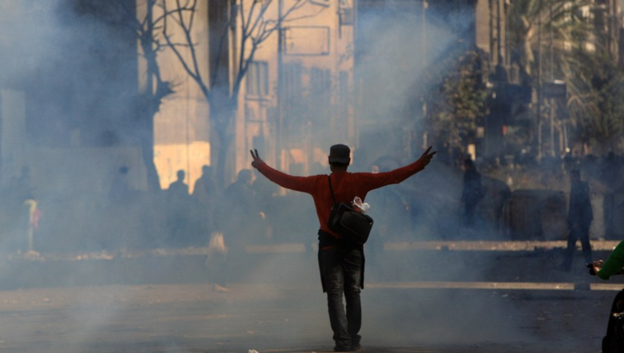 Demonstrant op het Egyptische Tahrirplein te midden van een wolk traangas. Beeld afp