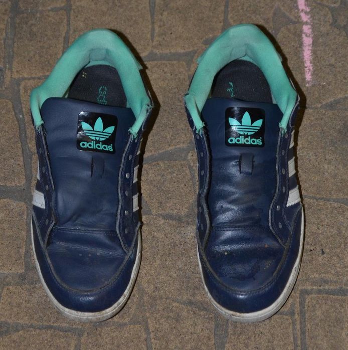 Tijdens zijn vlucht verloor de dader zijn beide sportschoenen: donkere baskets met groene afwerking en drie witte strepen, van het merk Adidas.