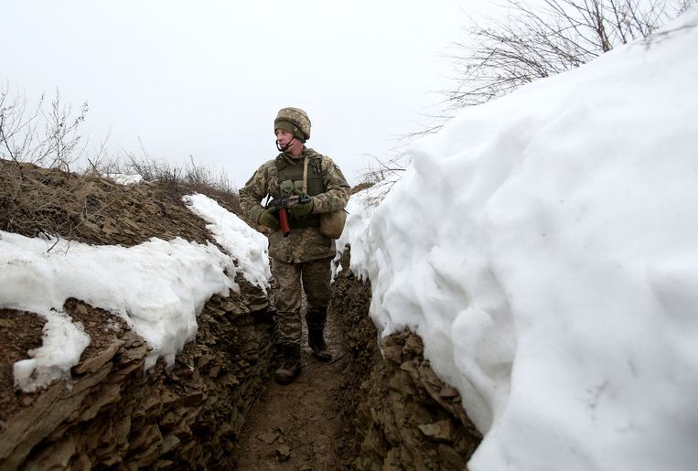 Een Oekraïnse militair loopt door een loopgraaf bij het front met de door Rusland gesteunde Oost-Oekraïense separatisten. Aan de Russische kant van de grens met Oekraïne heeft Rusland 100 duizend militairen samengebracht. Beeld Anatoli Stepanov / AFP