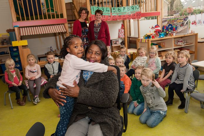 De grootmoeder van Deedee zorgt voor haar kleindochter en vecht tegen de uitzetting naar Liberia van deze kleuter. Op achtergrond: directeur Clazien Sonneveld (links) en juf Esther Borst (rechts) en de kinderen uit de klas van Deedee.