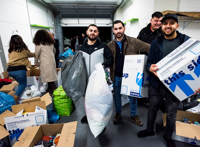 Inzameling van goederen voor de slachtoffers van de aardbevingen in Turkije. Met in het midden initiatiefnemers Mehmet Yildirim (met twee zakken) Oguzhan Oktem (met doos).