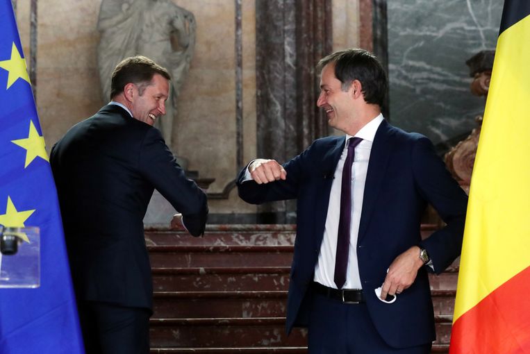 Alexander De Croo (rechts), de nieuwe premier van België, begroet Paul Magnette van de Waalse socialisten. Beeld Reuters