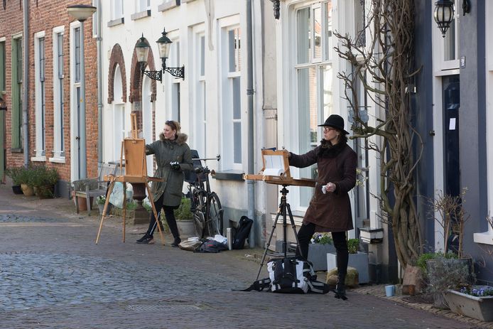 Wencke Vinks (op voorgrond) en Anouk Bijsterbosch schilderen oude gevels in het centrum van Doesburg.