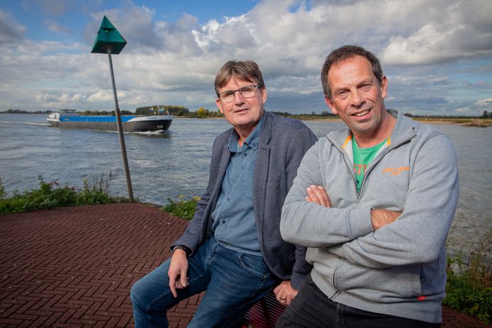 Dick Sonneveld (links) en Jan Willem Drost aan de Waal bij Druten. ‘Er zitten bij ons meer mensen dan in de Ewaldenkerk.’