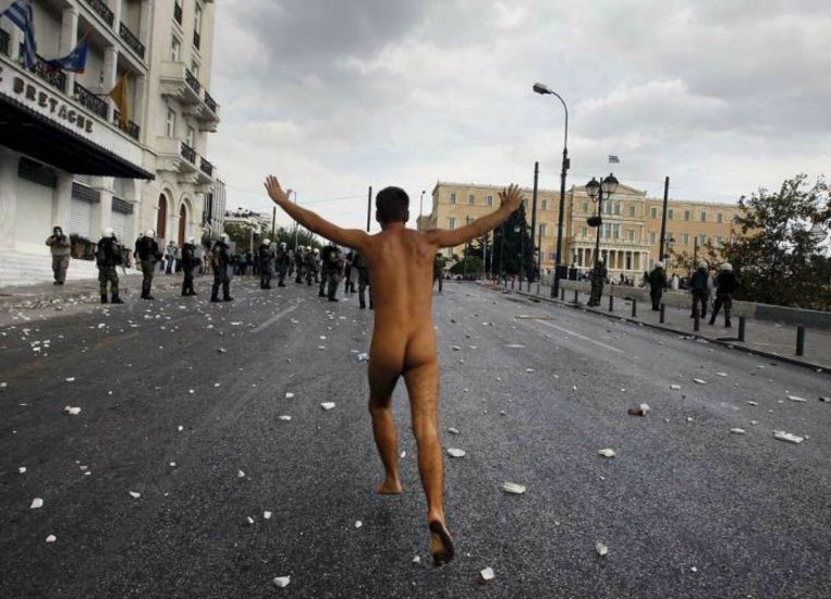 Oktober 2012. Een Griekse demonstrant protesteert in Athene op geheel eigen wijze tegen een bezoek van bondskanselier Angela Merkel. Beeld reuters