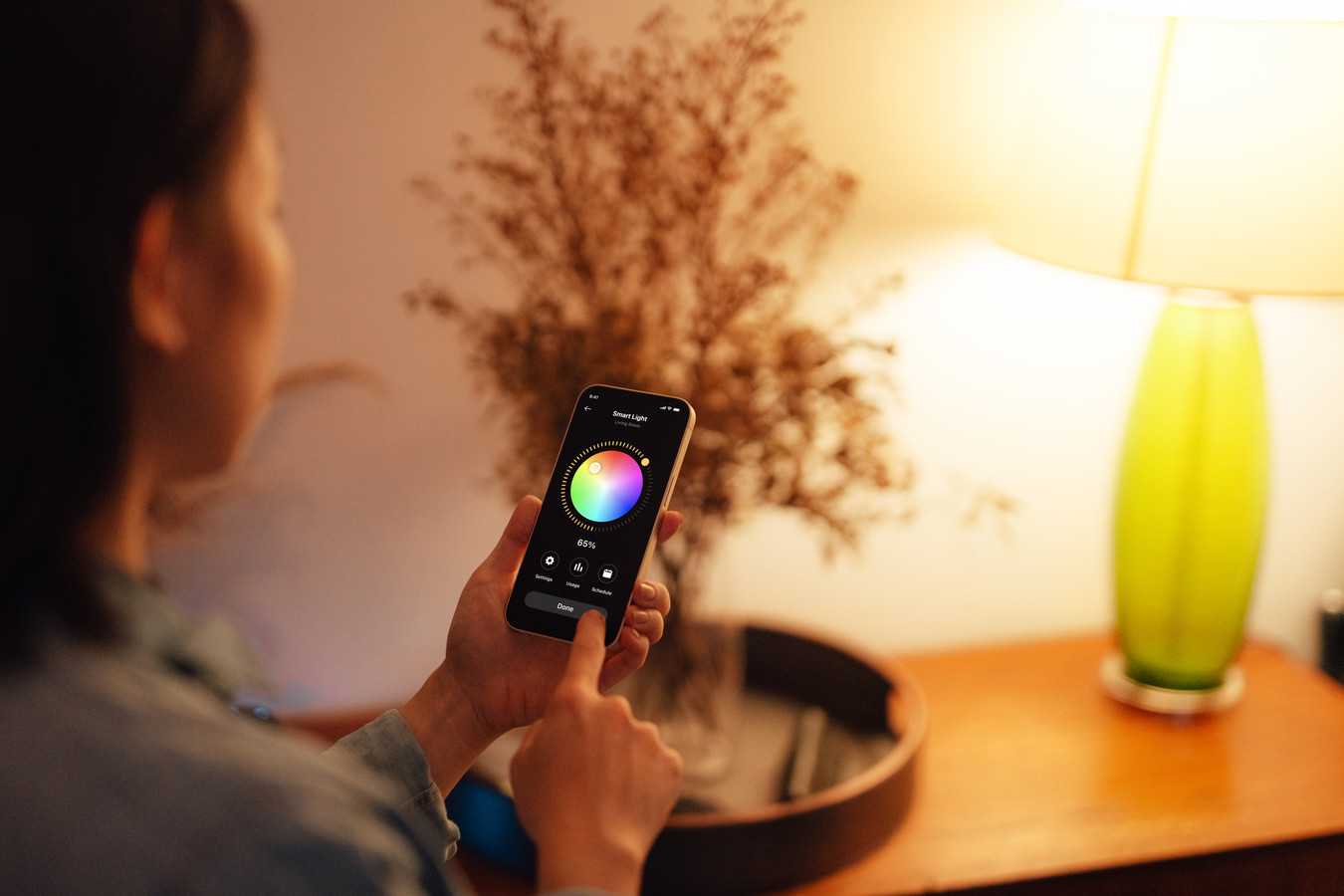 Een vrouw zet een smartlamp aan.