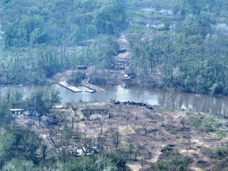 Een luchtfoto van de rivier Donets waarop de weggeslagen brug en uitgebrande legervoertuigen te zien zijn. Beeld Reuters