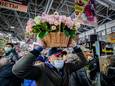 Een man draagt een mand met bloemen door een markthal in Moskou, vlak voor Internationale Vrouwendag vorig jaar.
