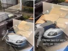 Il tente de sauver sa voiture de la grêle... en se couchant dessus avec des cartons