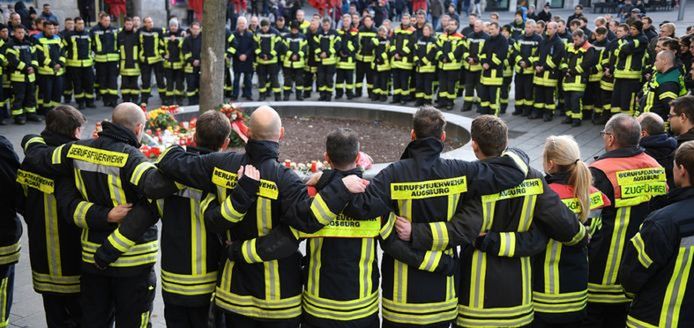 Brandweerlieden uit Augsburg herdenken hun collega op de plaats delict, twee dagen nadat hij werd doodgeslagen.