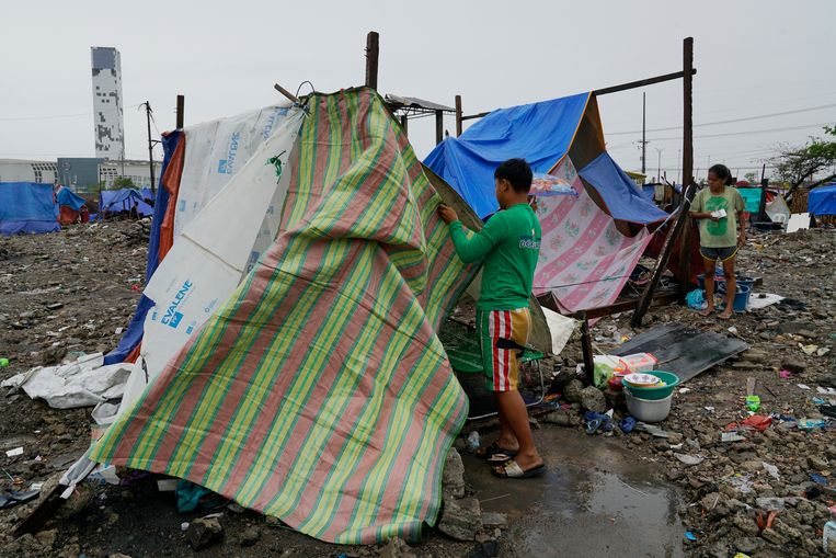 Inwoners van de provincie Cebu op de Filipijnen maken hun tent in orde. Honderdduizenden huizen zijn vernield door de tyfoon Rai. Beeld AP