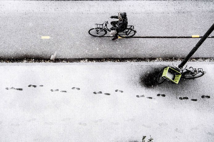 Een fietser door de verse sneeuw in Rotterdam. Foto Robin Utrecht