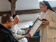 Priorin zr. Maria Magdalena laat een mede-zuster de oorkonde zien die hoort bij het ereburgerschap.