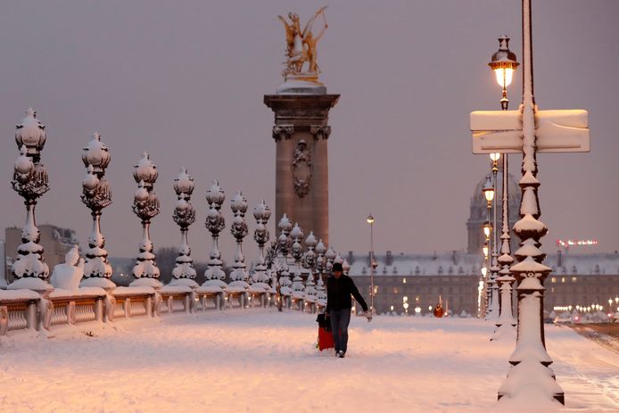 Parijs in de sneeuw. Voorbijgangers lieten de gevallen man volledig links liggen.