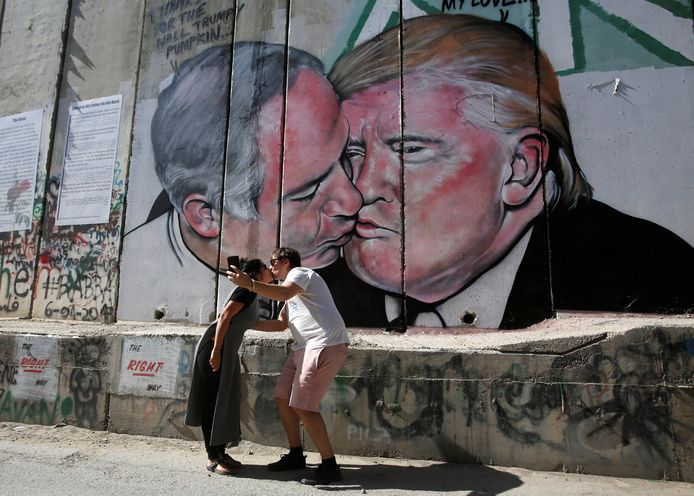 Een muurtekening in Bethlehem, op de Westelijke Jordaanoever, toont Trump die de Israëlische premier Netanyahu kust. T