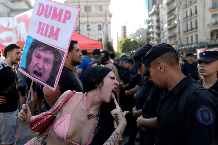 Een demonstrant drijft de spot met de politie in Buenos Aires tijdens het debat in het parlement.