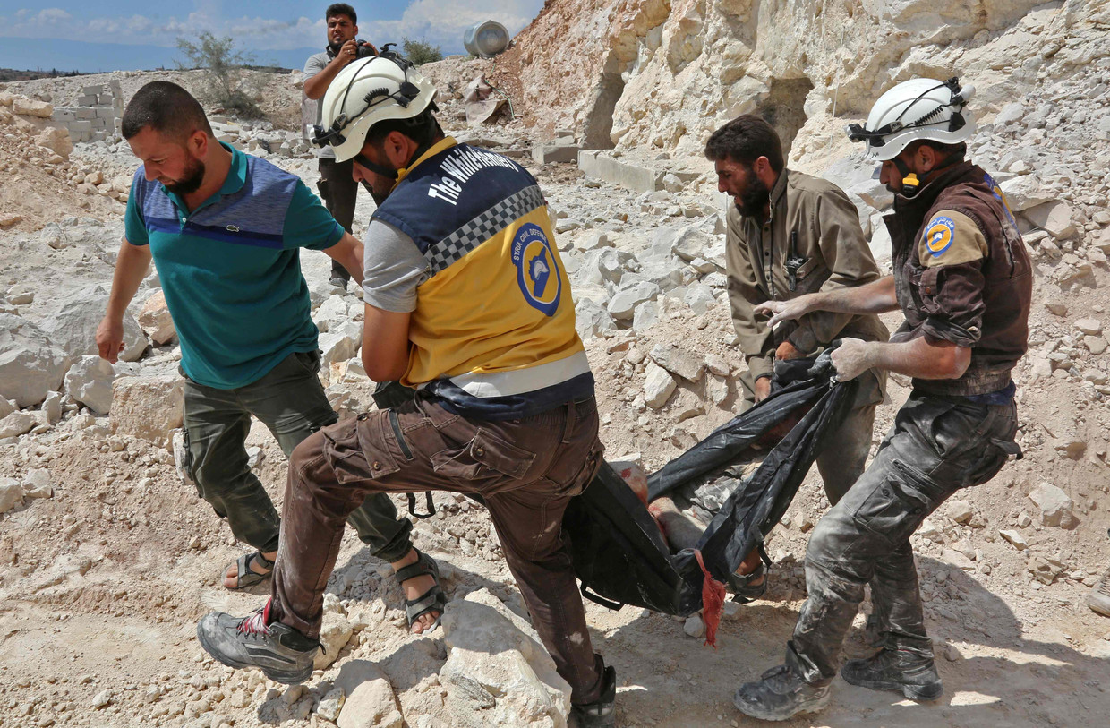 Leden van de Witte Helmen ruimen lijken na aanvallen in Idlib.
 Beeld AFP