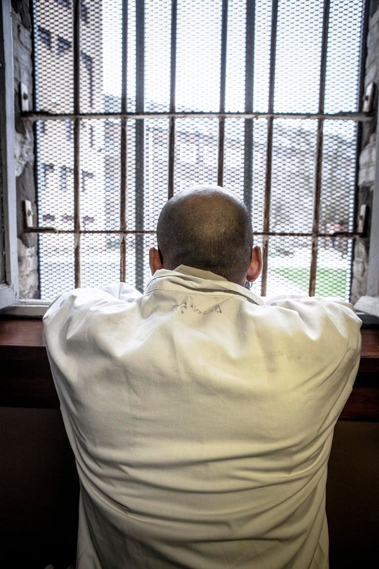 Een gevangene kijkt uit het raam. Sommige veroordeelden hebben een deeltijds celregime, andere niet. Dat zorgt voor conflicten. Beeld © Filip Van Roe /Reporters