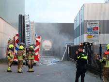 Zak met chemisch afval vliegt in brand bij bedrijf in Waspik, brandweerlieden klimmen over hek