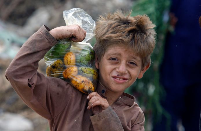 Een jonge Afghaanse vluchteling draagt een zak mango's op zijn schouder in Karachi, Pakistan. De foto werd afgelopen maand gemaakt.