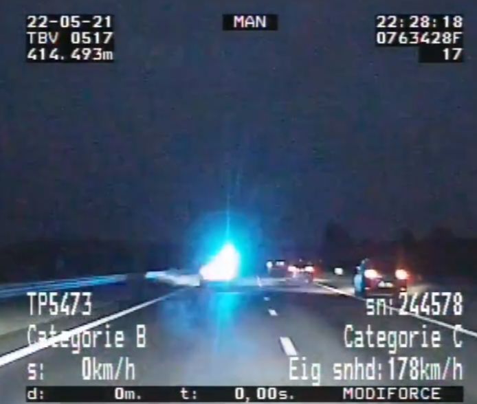 Een politieauto probeert de achtervolgde auto (die op dit beeld op de vluchtstrook een andere auto inhaalt) af te remmen.