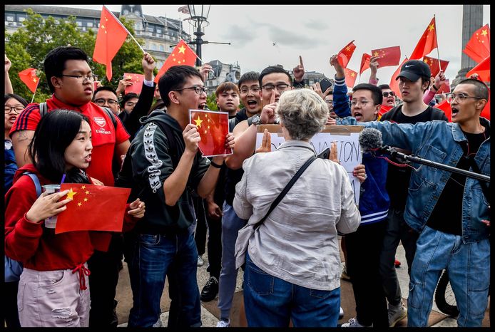 Opstootje tussen een demonstrante en een groep Chinese tegenbetogers.