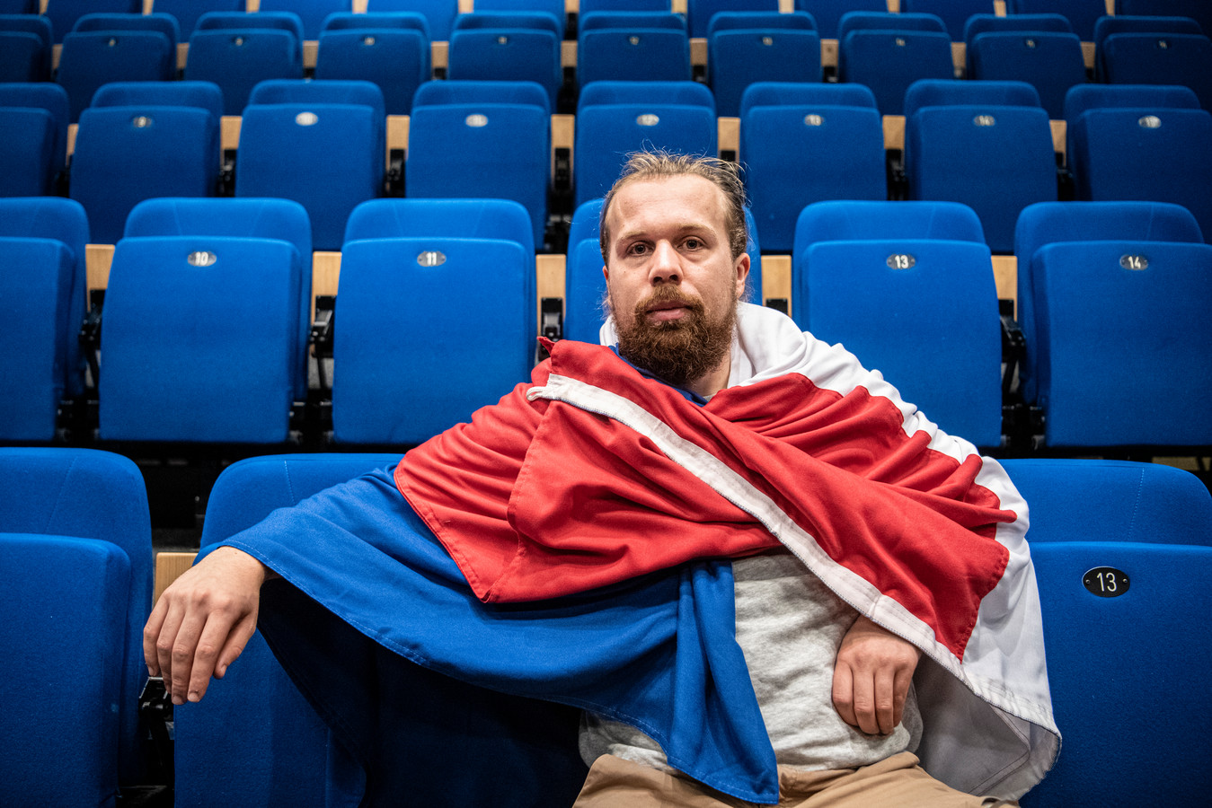 Simon Versteeg in ’t Mozaïek, gehuld in de Nederlandse vlag, die als rekwisiet een belangrijke rol speelt in de voorstelling ‘De situatie in de kampen’.