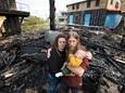 Het getrofen paar Annegreet en Bouke met hun zoontje Nour op de verkoolde resten van hun droomhuis in aanbouw in Culemborg.