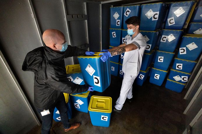 Robin Arts (rechts) en zijn baas Merijn Klabbers, van de afdeling Logistieke Services. Ze zijn in de weer met vaten vol corona-afval.