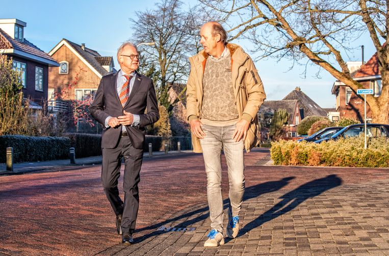 Burgemeester Lokker (l) en actievoerder Jacques Versluis lopen gezamenlijk door Meerkerk. Beeld Foto Raymond Rutting