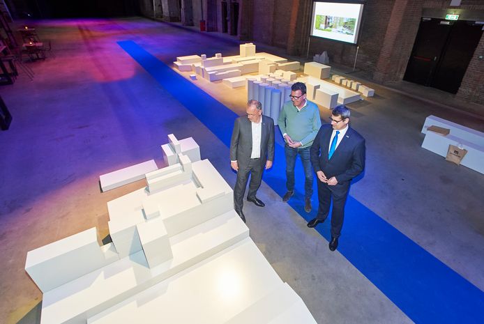 Stefan van de Ven (midden) met wethouder Jan Goijaarts en gedeputeerde Erik Ronnes (rechts) bij de maquette in de koekbouw.