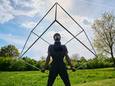 Straatkunstenaar  Frank Chikalombe demonstreert een acrobatische act met kubus.