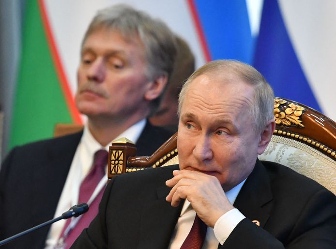 De Russische president Vladimir Poetin met links Kremlin-woordvoerderDmitry Peskov.