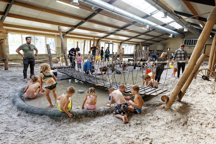 Kinderen aan het spelen in de poel en op het zand bij speelboerderij Gouden Woud in Liempde.