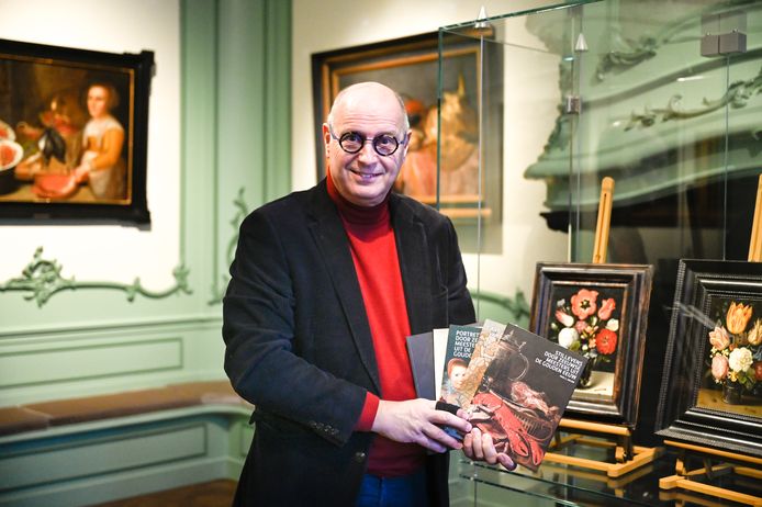 Albert Scheffers met de boekenserie in de tentoonstellingsruimte waar de stillevens zijn te zien