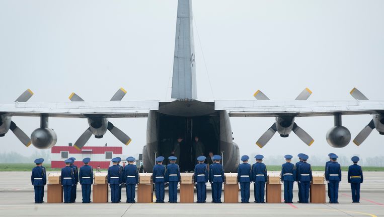 Kisten met stoffelijke resten van slachtoffers van MH17 werden op de luchthaven van Charkov in een Hercules-transportvliegtuig van de Koninklijke Luchtmacht gedragen. Beeld ANP