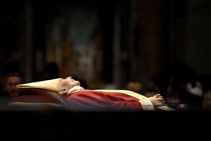 Vêtu de rouge (la couleur du deuil papal) et coiffé d’une mitre blanche, la dépouille de Benoît XVI repose devant l’autel principal de la basilique Saint-Pierre de Rome.