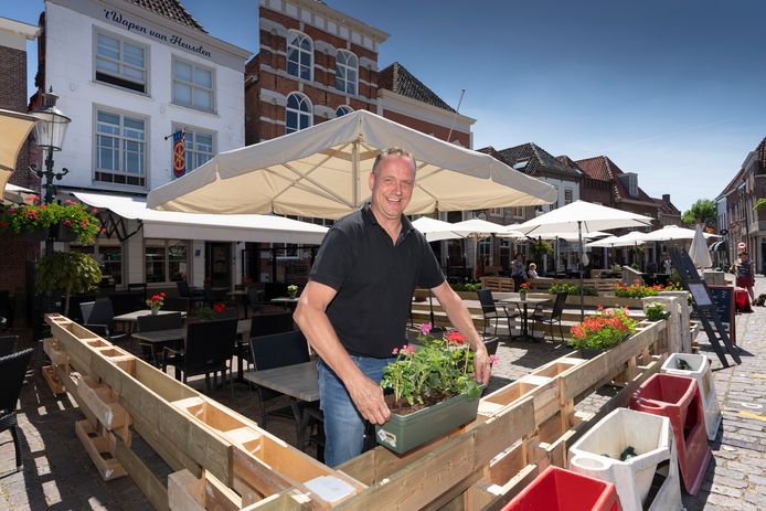Peter Klerkx  uitbater van het Wapen van Heusden zet de bloembakken op zijn plek op het aangepaste coronaterras.