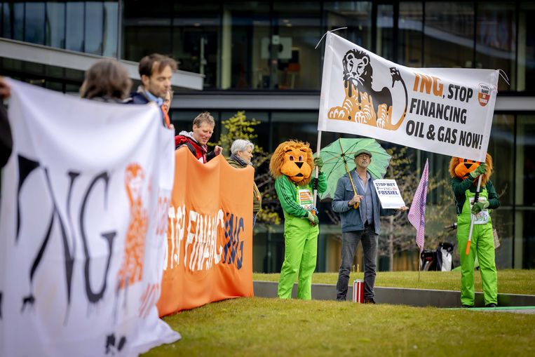 Oranje leeuwen in groene overalls bij het hoofdkantoor van ING protesteren tegen het financieringsbeleid van de bank. Beeld ANP, Robin van Lonkhuijsen