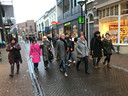 Deelnemers aan een 'creatieve wandeling' door het centrum van Oss onder leiding van centrummanager Jac van Lieshout (met zwarte das)