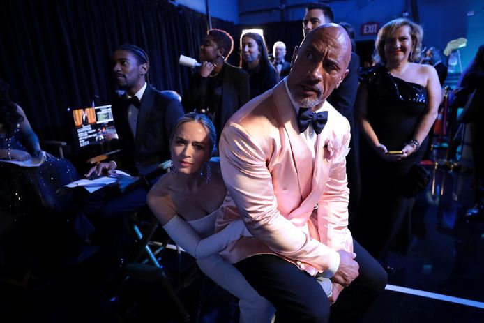 Dwayne Johnson sur les genoux d'Emily Blunt en coulisses.